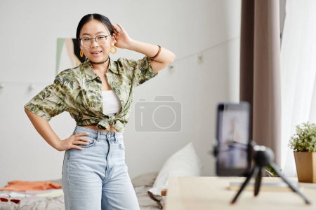 Photo for Portrait of smiling Asian teenager filming dance video for social media trend at home, copy space - Royalty Free Image