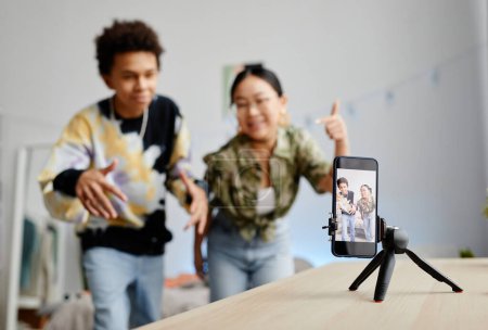 Photo for Background image of two gen Z teenagers filming video for social media, focus on smartphone screen, copy space - Royalty Free Image