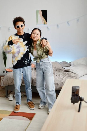 Photo for Full length portrait of two gen Z teenagers filming video for social media, boy and girl posing for smartphone recording - Royalty Free Image