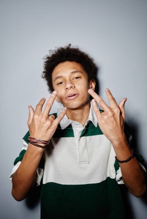 Foto de Retrato vertical del adolescente negro mirando a la cámara y haciendo gestos con flash - Imagen libre de derechos