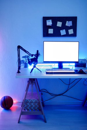 Téléchargez les photos : Image de fond verticale de la salle de jeux avec éclairage au néon bleu et maquette de l'écran blanc du PC - en image libre de droit