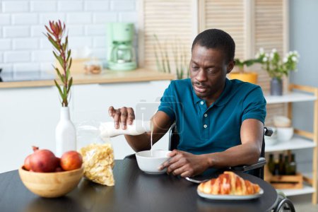 Photo for Portrait of black adult man with disability enjoying light breakfast in elegant home kitchen, copy space - Royalty Free Image