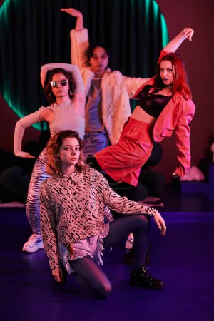 Foto de Retrato vertical completo del equipo de baile de moda posando en luz de neón rosa - Imagen libre de derechos