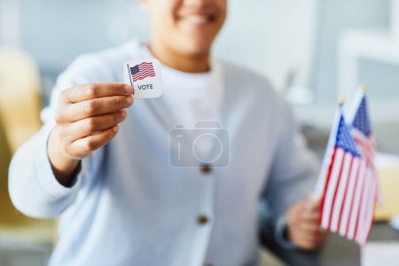 Téléchargez les photos : Gros plan de la personne détenant l'autocollant de vote et le drapeau américain, mise au premier plan, espace de copie - en image libre de droit