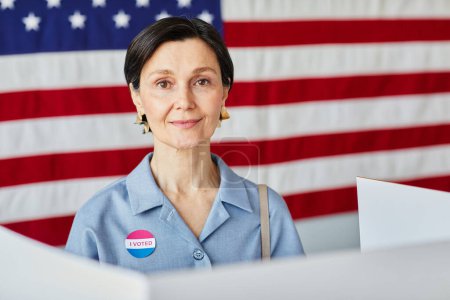 Téléchargez les photos : Portrait de femme adulte souriante votant contre fond de bannière des États-Unis, espace de copie - en image libre de droit