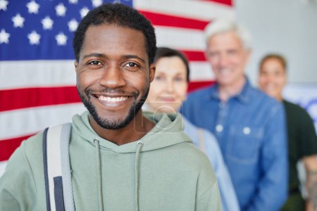 Téléchargez les photos : Portrait tête et épaules d'un homme noir souriant en ligne avec divers groupes de personnes votant contre le drapeau des États-Unis, espace de copie - en image libre de droit