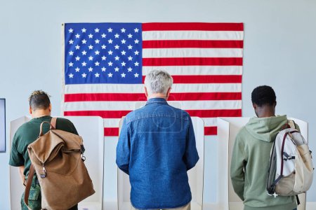 Téléchargez les photos : Vue de dos à trois personnes différentes votant en rang aux stands contre le drapeau américain, espace de copie - en image libre de droit