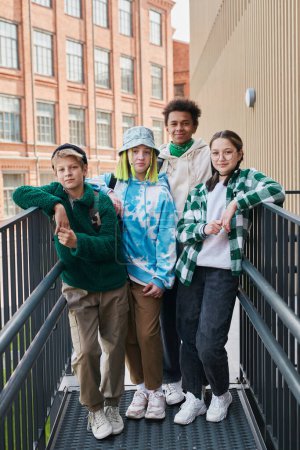 Téléchargez les photos : Portrait d'un groupe d'adolescents multiethniques branchés regardant la caméra pendant qu'ils traînent après l'école - en image libre de droit