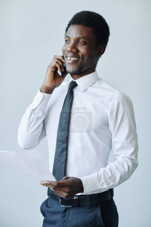 Photo for Minimal portrait of professional black businessman speaking on phone against white background - Royalty Free Image