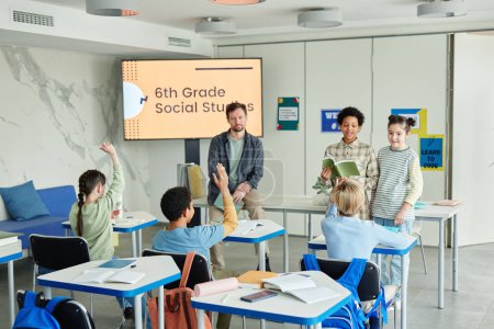 Téléchargez les photos : Vue grand angle de la salle de classe de l'école avec un groupe diversifié d'enfants en 6e année Études sociales - en image libre de droit