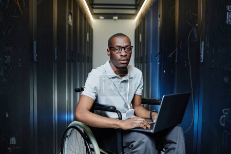 Photo for Portrait of African American man using wheelchair working as IT technician in server room - Royalty Free Image