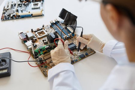 Close up of female engineer working with hardware parts in laboratory, copy space