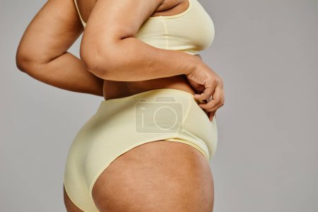Photo for Minimal closeup of unrecognizable black woman wearing underwear against grey background, focus on hips and cellulite, body positivity - Royalty Free Image