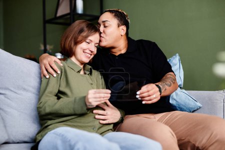 Téléchargez les photos : Portrait de couple gay heureux avec une jeune femme enceinte regardant l'image échographique du bébé, famille de même sexe - en image libre de droit