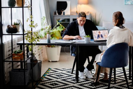 Téléchargez les photos : Image pleine longueur graphique de deux femmes d'affaires modernes travaillant à table avec des meubles en métal loft, espace de copie - en image libre de droit