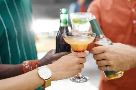 Téléchargez les photos : Gros plan d'amis cliquetis divers verres d'alcool tout en appréciant la fête en plein air - en image libre de droit