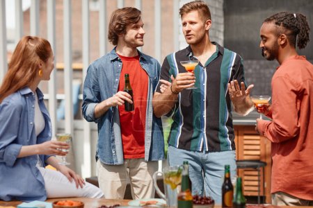 Foto de Retrato de dos jóvenes celebrando una cena al aire libre con un grupo diverso de amigos - Imagen libre de derechos