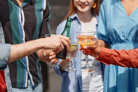 Foto de Primer plano de amigos multiétnicos disfrutando de bebidas en la fiesta al aire libre a la luz del sol - Imagen libre de derechos
