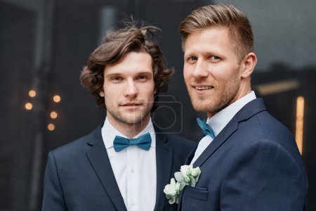 Photo for Portrait of two smiling young men wearing suits during wedding ceremony, same sex marriage concept - Royalty Free Image