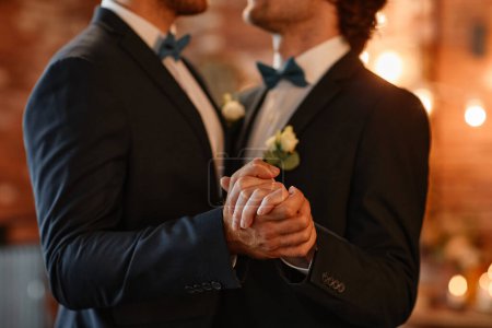 Foto de Primer plano de pareja gay masculina bailando juntos durante la ceremonia de boda y tomados de la mano, espacio de copia - Imagen libre de derechos