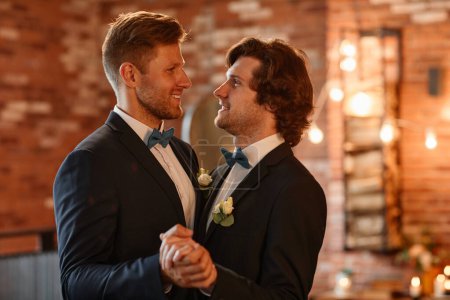 Photo for Portrait of male gay couple dancing together during wedding ceremony and holding hands, copy space - Royalty Free Image