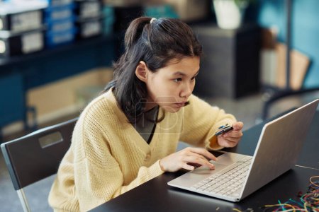 Photo for Portrait of young Asian girl using laptop in engineering class and programming robot, copy space - Royalty Free Image