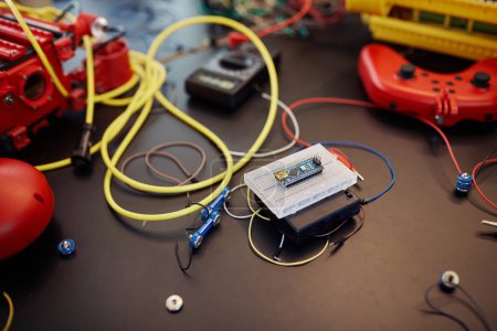 Téléchargez les photos : Fermeture du circuit imprimé avec fils et câbles dans une classe d'ingénierie robotisée ou une activité d'atelier - en image libre de droit