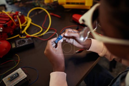 Foto de Primer plano del chip de circuito de retención de niños mientras se construye el robot en clase de ingeniería, espacio de copia - Imagen libre de derechos