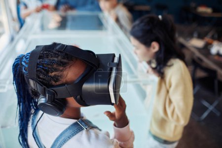 Foto de Retrato de alto ángulo de una adolescente negra con auriculares VR en clase brillante en la escuela moderna - Imagen libre de derechos