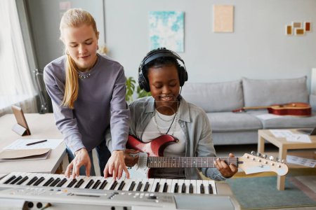 Photo for Portrait of two young women playing music together and composing song in studio or at home, copy space - Royalty Free Image