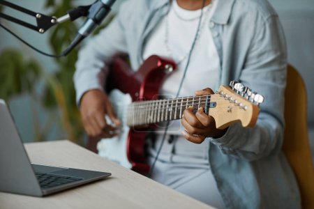 Téléchargez les photos : Gros plan de femme noire méconnaissable jouant de la guitare électrique et enregistrant de la musique à la maison, espace de copie - en image libre de droit