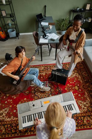 Téléchargez les photos : Vue de dessus de divers groupes de musique jouant des instruments tout en pratiquant en studio sur tapis d'ornement lourd - en image libre de droit