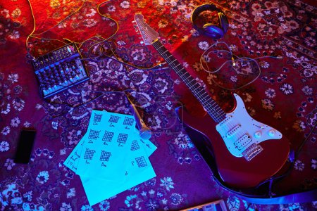 Foto de Vista superior de fondo de la guitarra eléctrica y notas de música en alfombra adornada en el estudio en casa, espacio de copia - Imagen libre de derechos