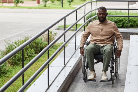 Téléchargez les photos : Portrait complet de l'homme noir adulte handicapé descendant la rampe en ville, accessibilité urbaine - en image libre de droit