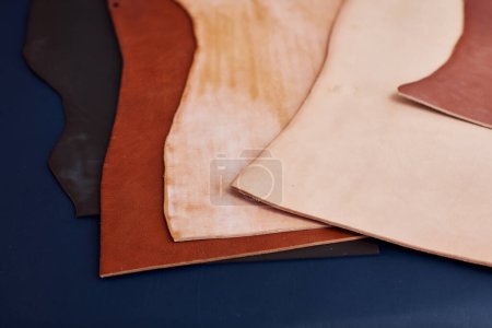 Téléchargez les photos : Gros plan des pièces en cuir véritable sur la table dans la boutique artisanale, espace de copie - en image libre de droit