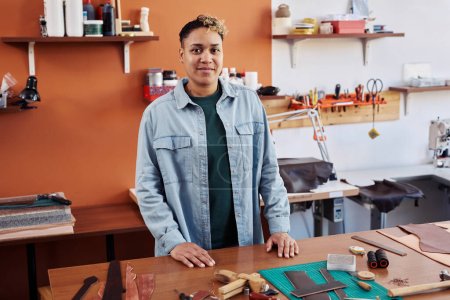 Téléchargez les photos : Portrait d'une artisanale multiethnique dans un atelier souriant à la caméra fière d'une petite entreprise prospère - en image libre de droit