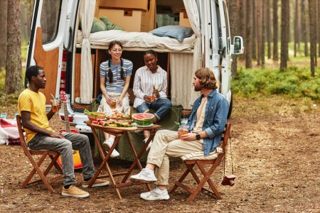Téléchargez les photos : Groupe d'amis pique-niquer en camping-car dans la forêt - en image libre de droit