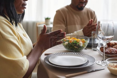 Téléchargez les photos : Gros plan du couple africain priant ensemble à table avant le dîner - en image libre de droit
