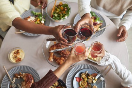 Foto de Vista en ángulo alto de la familia de cuatro tostadas con bebidas juntas en la mesa durante la cena de vacaciones - Imagen libre de derechos