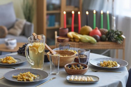 Téléchargez les photos : Gros plan de la table à manger avec de la nourriture et des boissons sur la table à manger préparant les vacances à Kwanzaa - en image libre de droit
