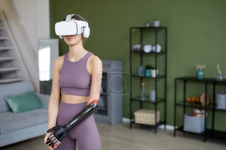 Photo for Young girl with disability using virtual reality glasses during sport training at home - Royalty Free Image