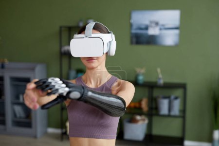 Foto de Mujer joven en gafas de realidad virtual de entrenamiento en la habitación en casa - Imagen libre de derechos