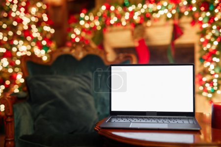 Téléchargez les photos : Gros plan de l'ordinateur portable ouvert avec écran blanc maquette et décorations de Noël en arrière-plan, espace de copie - en image libre de droit