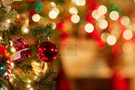 Foto de Cerrar imagen de fondo de adorno rojo único en el árbol de Navidad con luces centelleantes, espacio de copia - Imagen libre de derechos