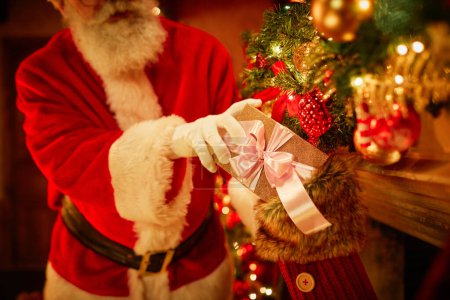 Foto de Primer plano de Santa Claus tradicional poner presente en las medias sobre la chimenea en Navidad, espacio de copia - Imagen libre de derechos