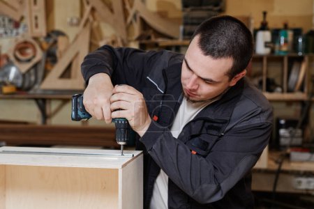 Téléchargez les photos : Portrait de travailleur masculin construisant des meubles en bois dans l'atelier d'usine, espace de copie - en image libre de droit