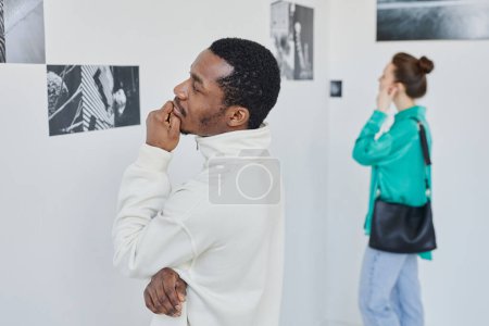 Photo for Minimal side view portrait of two people looking at photography in art gallery, copy space - Royalty Free Image