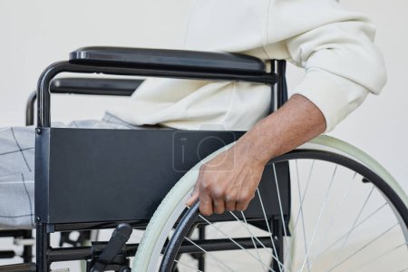 Photo for Side view closeup of young man using wheelchair against white, copy space - Royalty Free Image