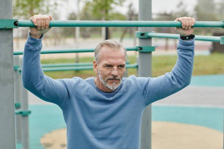 Photo for Portrait of handsome mature man working out outdoors and looking away with motivation in minimal city setting - Royalty Free Image