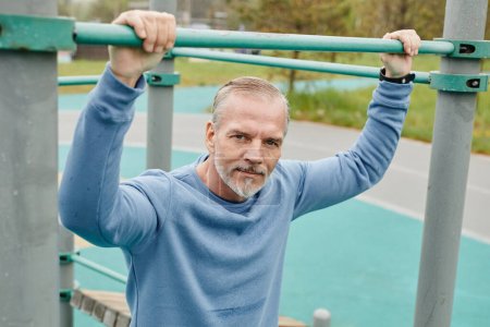 Photo for Portrait of active mature man working out outdoors and looking at camera in minimal city setting - Royalty Free Image